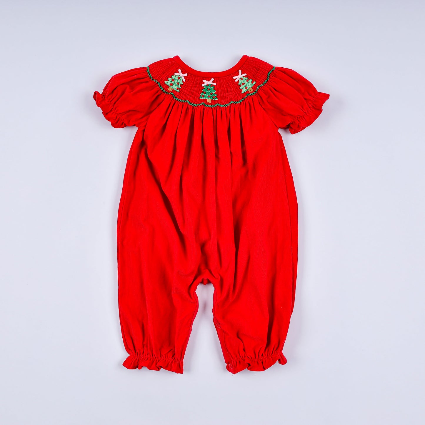 Red baby romper with green embroidery on a white background